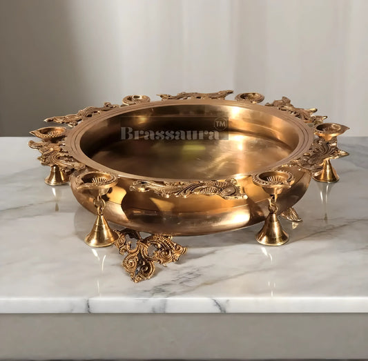 Brassaura™ Magnificent Peacock Brass Urli – 16 kgs, 7.5 Inches Height – Decorative Urli with 6 Diyas & Bells for Home Decor